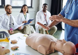 instructor teaching class on CPR dummy
